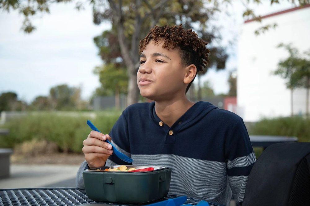 Boy eating food with the HeatsBox Go