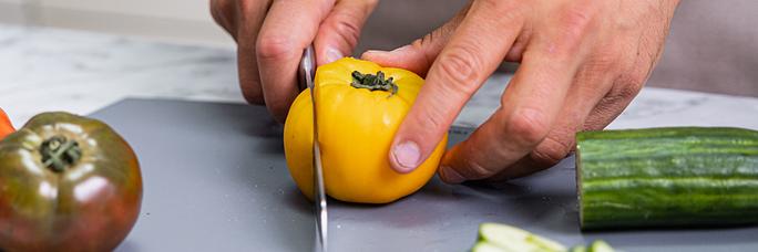 Cutting tomato on cutting board