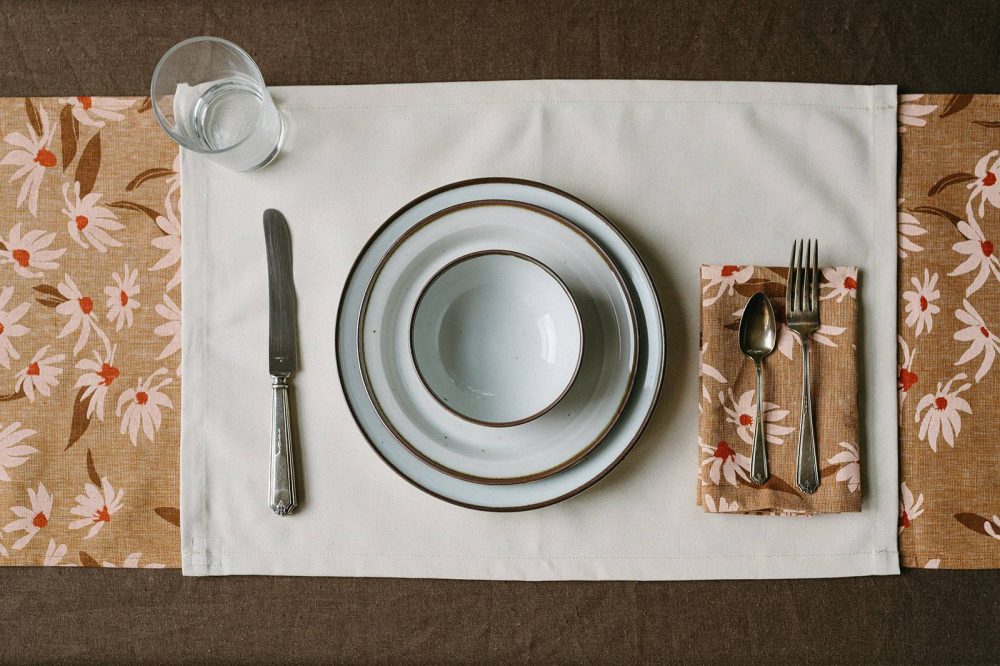 Place setting with eco-friendly linen napkins, placemat, cutlery, and dishes