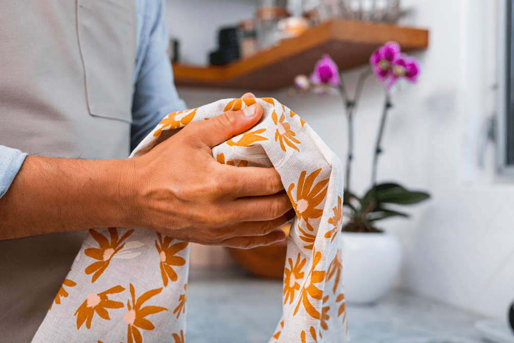 Man drying his hands with a linen tea towel