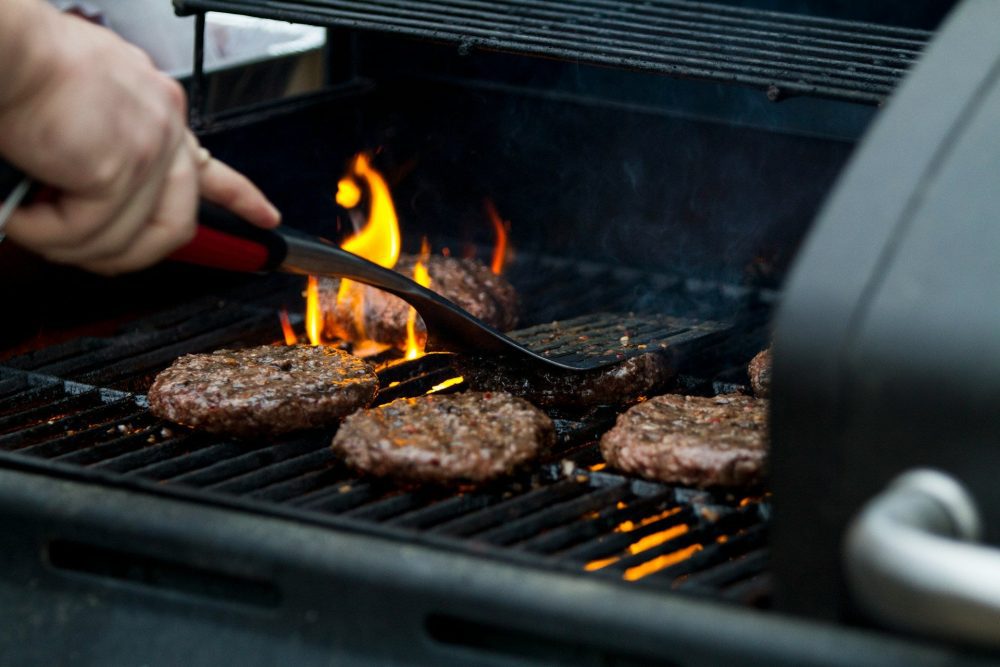 Person grilling hamburgers on the barbecue