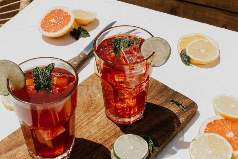 Two glasses of infused cocktails on a board